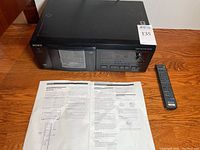 Sony CDP-CX53 compact disc player with remote control and instruction manual laid out on a table, top view.
