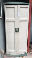 Front view of closed beige and green plastic vertical storage cabinet with two doors, padlock handle holes visible.