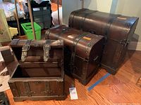 Three chests arranged with lids open and closed to show different angles and details of wood and metalwork.