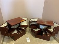 Pair of open multilevel dark wooden jewelry boxes showing drawers, cubbies, and compartments opened and fanned out.