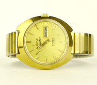 Front view showing gold-tone dial, day-date display, and expandable bracelet.