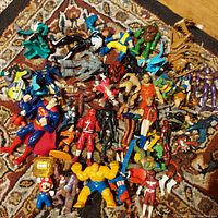 Overview of mixed lot of action figures from Marvel, DC, Star Wars, and wrestling including various characters like Superman, Wolverine, Mario, and Captain America.