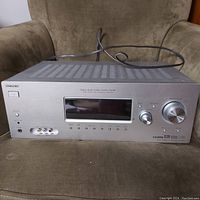 Front view of Sony STR-K900 AV receiver showing silver front panel, display, input/output controls, and power cable.