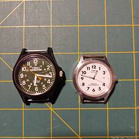 Two Timex quartz watches front view showing dial designs and cases without straps.