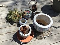 All six ceramic planters arranged on outdoor wooden surface, showing various sizes and Asian style decorations. One planter contains a Christmas cactus.