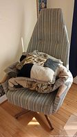 Chair with throw and pillow piled on seat