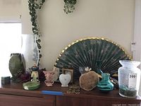 Photo showing Asian hand fan, multiple assorted vases, metal heart box, candle holders.