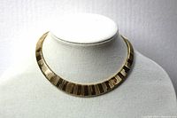 Front view of the gold tone choker necklace displayed on a mannequin bust, showing the ribbed pattern and two-tone gold finish.