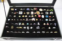 Full view of the rings in a black display case showing varied styles and sizes