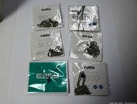 Six silver tone chain necklaces in their original packaging, each with colored rhinestone pendants in green, blue, and purple. Package branding visible as ESFY and price marked $10.00.