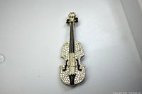 Front view of the brooch showing the silver tone metal base with rhinestones and black enamel details.