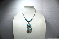 Front view of turquoise bead necklace displayed on bust, showing length and overall style.