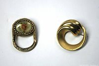 Both vintage gold tone brooches, one swirl-shaped, one eyeglass holder with rose cabochon