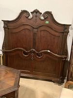 Full front view of the solid wood headboard with ornate carved scroll and floral motifs