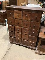 Front view showing twenty drawers in four columns of five rows, each with a round metal knob