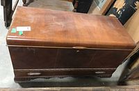 Front view of cedar chest showing top lid, push lock, and decorative trim