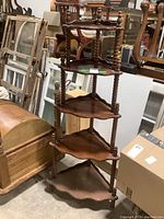 Photo showing the full wooden corner shelf unit with its five shelves and spindle supports, displaying the item's condition and construction.