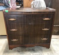 Front view of the three drawer wooden dresser showing drawer fronts and plastic pulls resembling metal and stone.