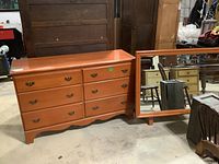 Full view of the dresser and matching mirror, showing the maple wood finish and drawer handles.