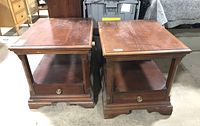 Two matching Broyhill wooden end tables side by side, showing overall design and condition including scratches on tops.