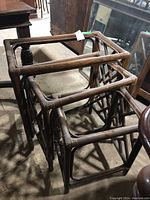 Set of three brown wooden nesting tables without glass tops, showing the nesting arrangement and frame details