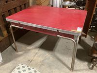 Full view of vintage Arborite table with red laminate top, metal legs with rubberized feet.