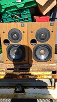 Pair of JBL bookshelf speakers placed upright, showing front view with wood veneer finish and speaker drivers.