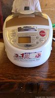 Front view of the white Tiger electric rice cooker with control panel, digital display, and 3-in-1 function sticker on the front.