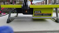Side view of the Ryobi tile saw showing the brand label and the saw motor housing.