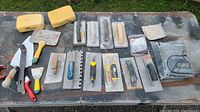 Top-down photo of the full collection of tiling hand tools spread out on a table for an overview.
