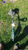 Yardworks electric weed wacker lying flat on grass showing full length and handle.