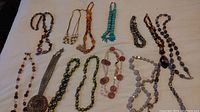 Image showing full assortment of necklaces laid out on a flat surface, highlighting varied bead sizes, colors, and types.
