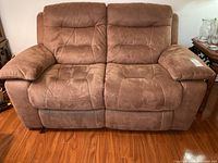 Front full view of the brown upholstered electric reclining love seat showing seat and backrest details.