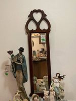 Front view of the framed hall mirror showing the decorative wooden frame with heart cutouts and beveled mirror glass.