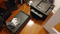 Lenovo Workforce Pro WF-3720 printer and Epson Perfection V550 scanner setup showing scanner with USB cable and manual on top, printer beside it.