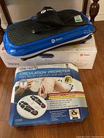 Lifepro Waver vibration plate atop its original box with Dr Ho’s Circulation Promoter box in front