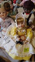 Image showing four collector dolls together, highlighting the yellow gingham dressed doll holding a plate and spider.