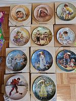 Twelve collector plates in boxes or displayed, showing detailed art of children and whimsical scenes.