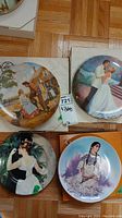 Four collector plates shown together including boxed rural Americana scene plate
