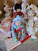 Four porcelain dolls on display, showing variety of outfits and facial features