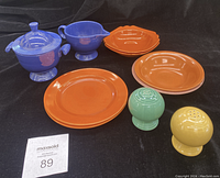 Photo showing entire set of 10 pieces including plates, bowls in orange and blue, salt and pepper shakers, creamer, and sugar bowl.