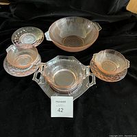 Top view of the glassware set with three small plates, two small bowls, one medium octagonal plate, one octagonal bowl, and one round bowl arranged on black background.