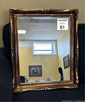 Front view of rectangular mirror showing beveled wood frame in bronze finish.