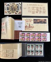 Top view of two stamp collection albums, a United States Bicentennial First Day commemorative cover dated July 4, 1976, blocks of Elvis Presley 29 cent stamps, blocks of Lou Gehrig 25 cent stamps, and a Russian stamp block from CCCP.