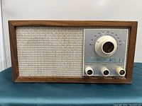 Front view of the KLH vintage FM radio showing speaker grille, tuning dial, and control knobs.