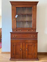 Front view of the antique pine hutch showing glass door upper cabinet, drawers, and lower cabinet doors.