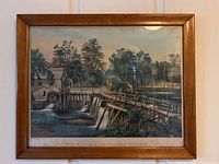 Wood frame with glass holding color lithograph of watermill and dam