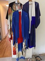 Front view of three silk kimonos, cobalt blue haori over red gradient kimono, purple kimono with obi belt