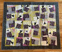 Full view of quilt showing multicolored patchwork and dark border.