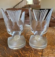 Front view of two glass swallow bookends showing detailed wings and heads, with minor chips visible on wings.